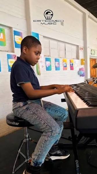 Young student playing piano at Esteemed Music studio