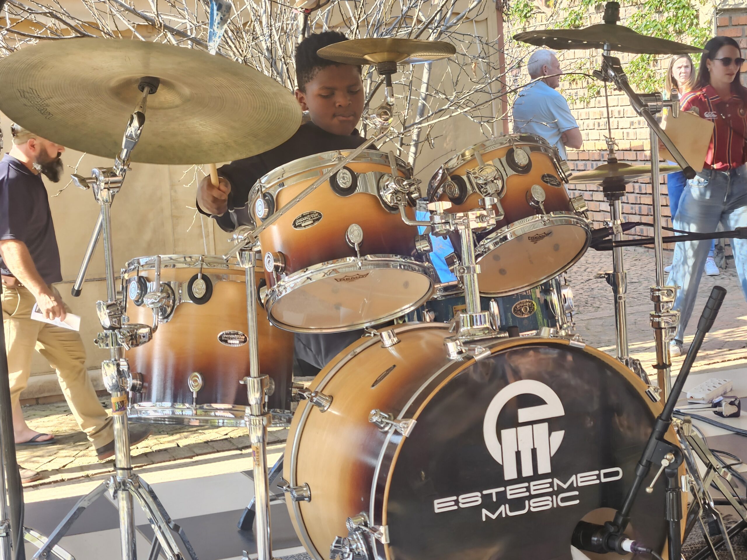 Young drummer performing at an Esteemed Music branded event